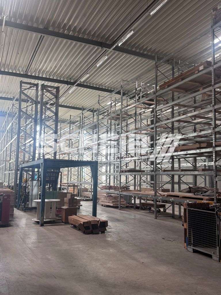 Hohe Lagerhalle mit Regalierung, Rampe und Versandbüro